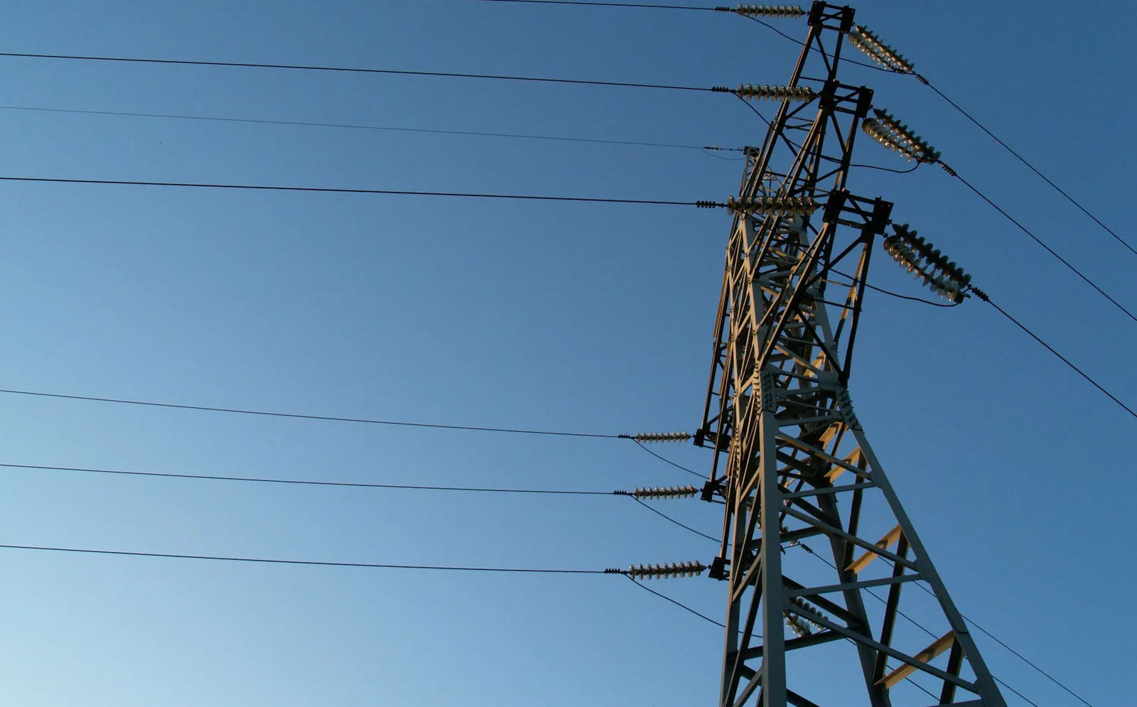 Transmission tower and conductors against a blue sky